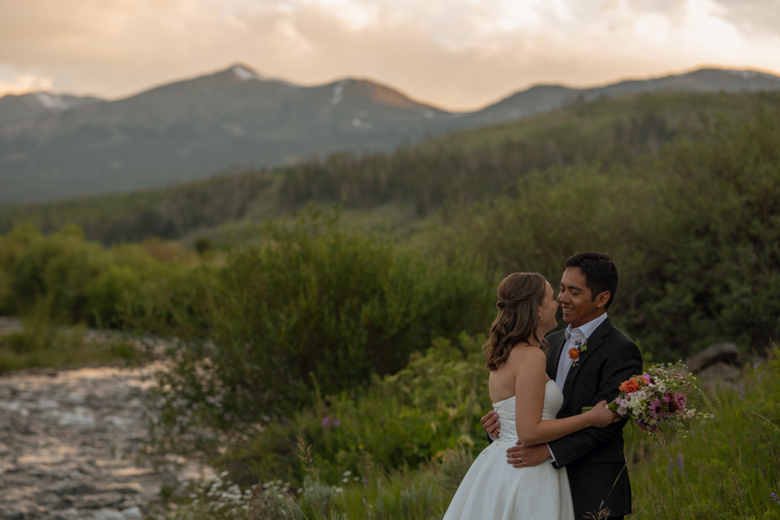 Couple eloping in Colorado mountains with wildflowers in July