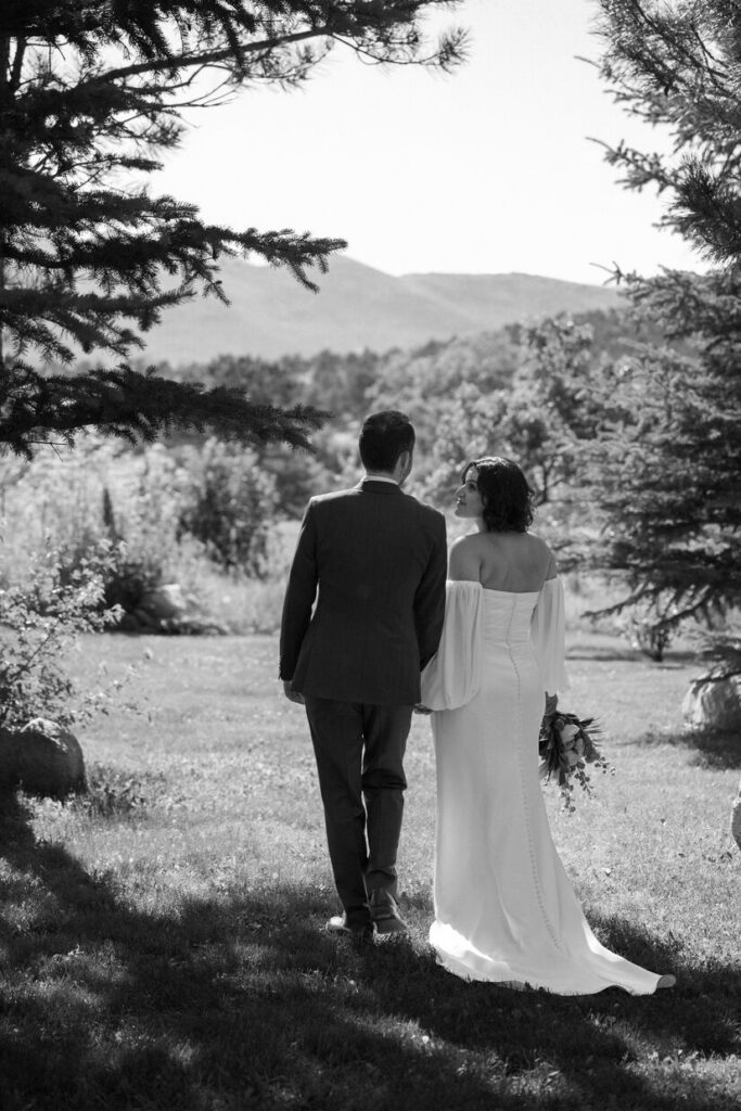 Black and white photo of bride and groom overlooking mountains at a micro wedding venue in Colorado