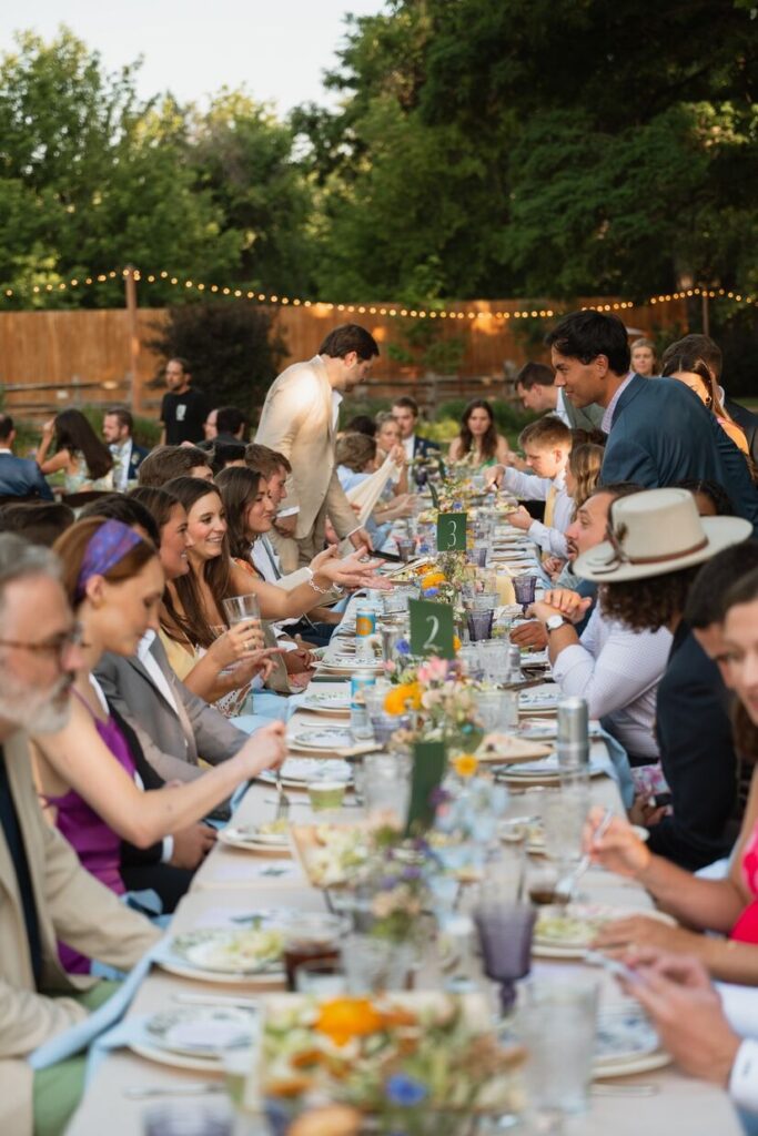 Guests sitting at tables with fresh flowers for a reception at a micro wedding venue in Colorado